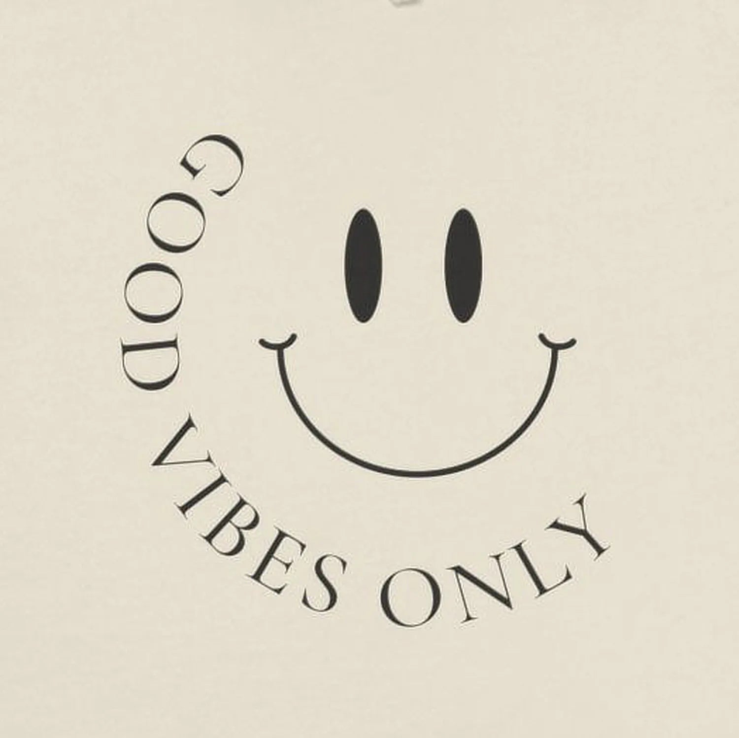 Close-up of minimalist “Good Vibes Only” smiley face front print.